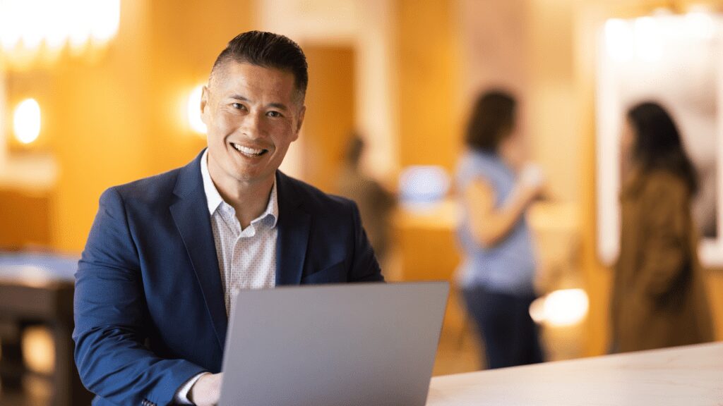 Man working on laptop in a cafeteria.